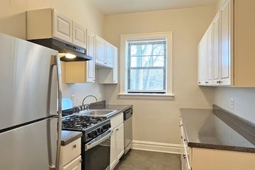 Oak Park apartment for rent - A kitchen with a stainless steel refrigerator and white cabinets.