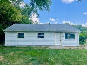 Louisville house for rent - A small white house with a grey roof and a brown door.