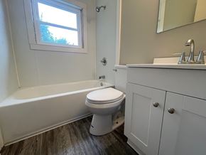 Louisville house for rent - A white toilet sits in a bathroom next to a bathtub.