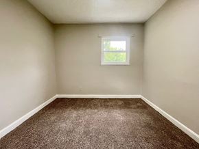 Louisville house for rent - A room with a carpeted floor and a window.