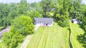 Charlestown house for rent - A house is surrounded by a lush green lawn and trees.