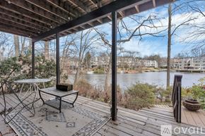 Reston house for rent - A balcony with a table and chairs overlooking a body of water.