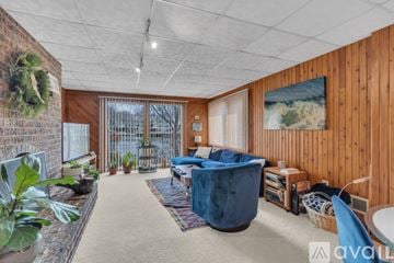 Reston house for rent - A living room with a blue sofa and a wooden wall.