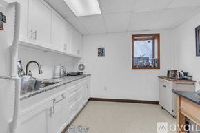Reston house for rent - A kitchen with white cabinets and a window.
