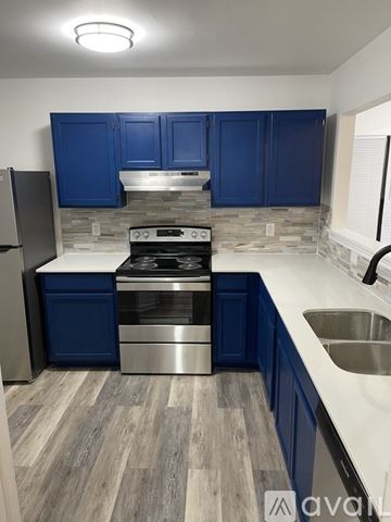 Killeen house for rent - A kitchen with blue cabinets and a stainless steel stove.