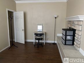 Corona apartment for rent - A room with a desk, chair, and a fireplace.
