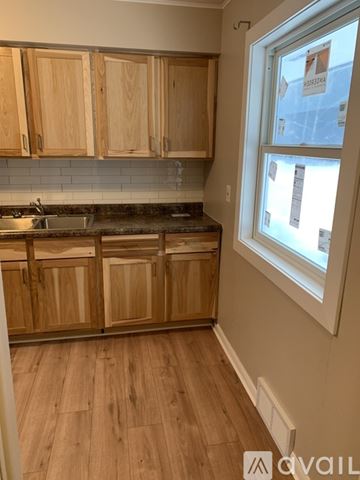 Sandstone apartment for rent - A kitchen with wooden cabinets and a window.