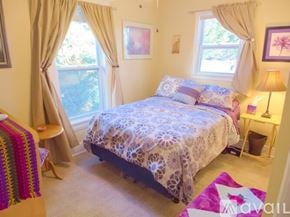 Roanoke apartment for rent - A bedroom with a bed, a lamp, and a window with curtains.