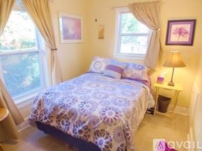 Roanoke apartment for rent - A bedroom with a bed covered in a purple and white patterned bedspread.