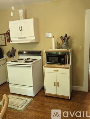 Roanoke apartment for rent - A small kitchen with a white stove and cabinets.