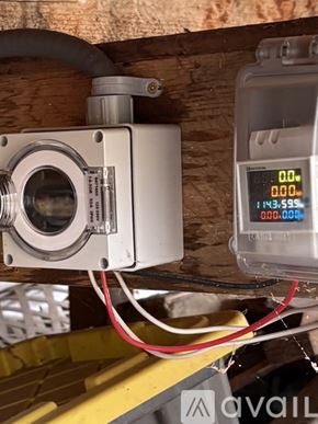 Jacksonville apartment for rent - A digital device with a white body and a silver lens is connected to a yellow structure with a red and black wire.