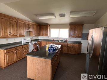 Oroville house for rent - A kitchen with wooden cabinets and a black countertop.