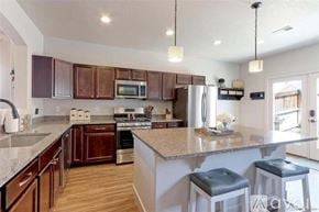 Thornton townhouse for rent - A kitchen with brown cabinets and a granite countertop.