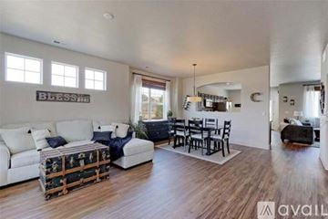 Thornton townhouse for rent - A living room with a white couch and a wooden floor.