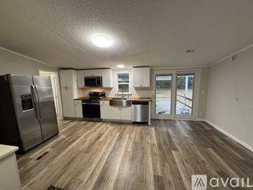 Gilmer house for rent - A kitchen with a refrigerator, microwave, oven, and sink is available for rent.