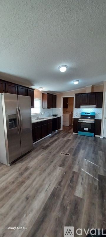 Kaufman house for rent - A kitchen with a refrigerator and wooden flooring.