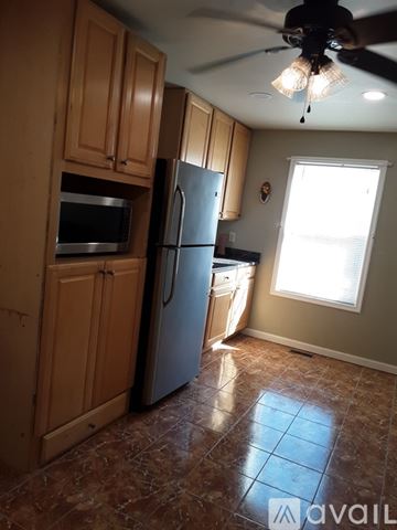 District Heights apartment for rent - A kitchen with a refrigerator, microwave, and cabinets.
