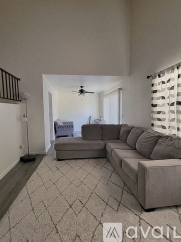 Suisun City house for rent - A living room with a grey sofa and a ceiling fan.