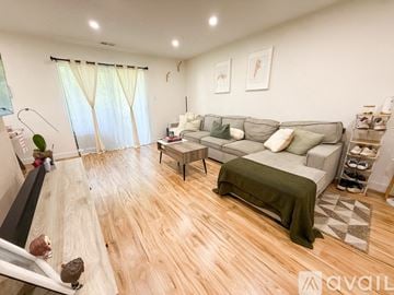 Bucks County apartment for rent - A living room with a grey couch and a green blanket.