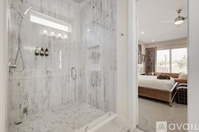 Dallas townhouse for rent - A bathroom with a walk-in shower and a bedroom with a bed and a window.