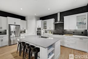 Dallas townhouse for rent - A modern kitchen with white cabinets and a large island.