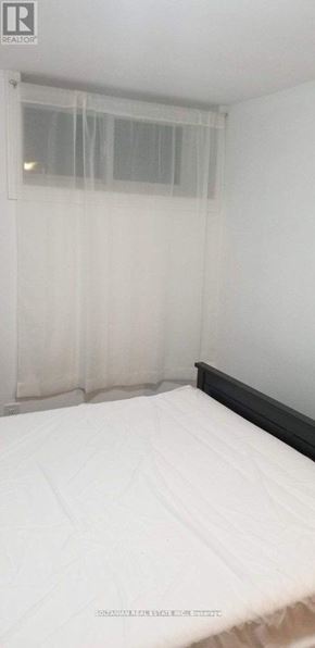 Toronto (West Hill) house for rent - A bed with white bedding in a room with a window covered by sheer curtains.