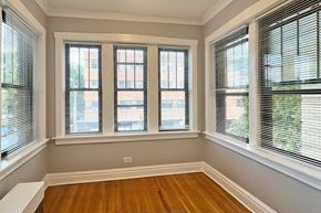 Oak Park apartment for rent - A room with wooden floors and three windows with blinds.