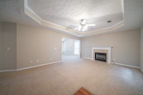 Columbus house for rent - A living room with a fireplace and a ceiling fan.