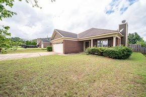 Columbus house for rent - A house with a brown roof and a garage is surrounded by a grassy lawn.