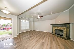 Edmond house for rent - A spacious living room with a fireplace and wood flooring.