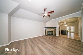 Edmond house for rent - A spacious room with a fireplace and a ceiling fan.