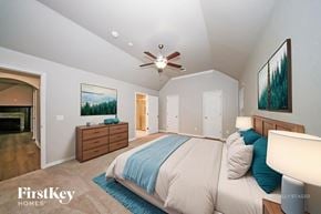 Edmond house for rent - A bedroom with a bed, dresser, and ceiling fan.