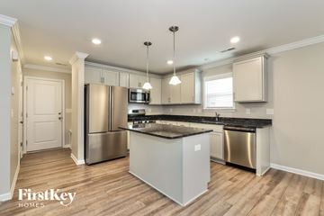 Jamestown house for rent - A kitchen with a stainless steel refrigerator and a wooden island.