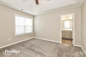 Jamestown house for rent - A spacious room with a carpeted floor and a ceiling fan.