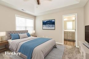 Jamestown house for rent - A bedroom with a large bed and a painting on the wall.