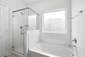 Houston house for rent - A white bathroom with a glass shower stall and a white tub.