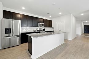 Houston house for rent - A modern kitchen with a white island and stainless steel appliances.