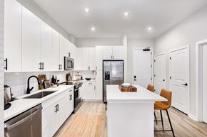 Charlotte apartment for rent - A modern kitchen with white cabinets and a wooden island.
