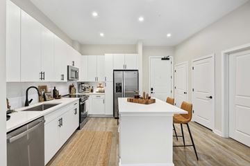 Charlotte apartment for rent - A modern kitchen with white cabinets and a wooden island.
