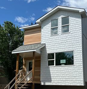 Edmonton apartment for rent - A white house with a brown wooden deck.