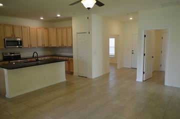Cape Coral house for rent - A kitchen with wooden cabinets and a black countertop.