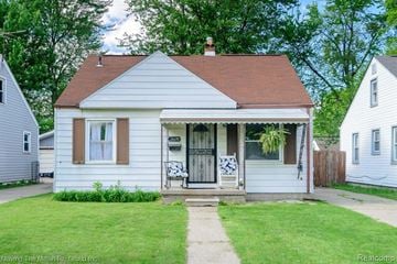 Dearborn Heights house for rent - A small white house with a brown roof and a porch.