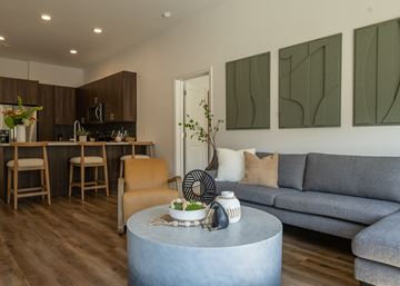 Olathe apartment for rent - A modern living room with a grey couch and a grey coffee table.