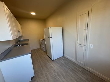 Alameda apartment for rent - A kitchen with white cabinets and a white refrigerator.