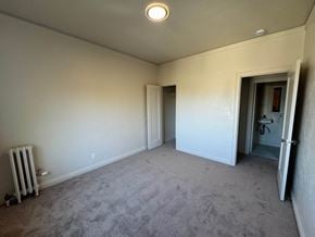Alameda apartment for rent - A room with a grey carpet and a white wall with a doorway leading to another room.