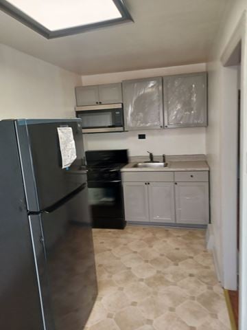 Philadelphia house for rent - A kitchen with a black fridge and a black oven.