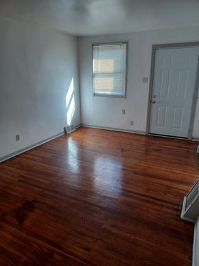 Philadelphia house for rent - A room with a wooden floor and a white door.