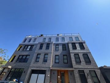 East Boston apartment for rent - A grey building with a brown door and windows on the second floor.