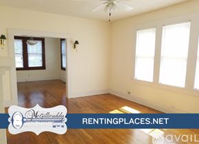 Augusta house for rent - A room with a fireplace and wooden floors.