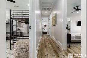 Hurricane house for rent - A hallway with a bedroom at the end and a bed with a white comforter.